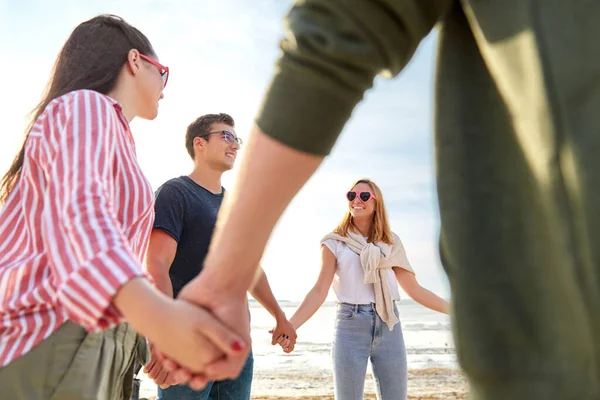 Boldog barátok kéz a kézben a nyári strandon Jogdíjmentes Stock Fotók