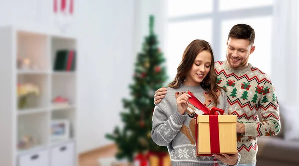 ギフトボックス付きのクリスマスセーターを着た幸せなカップル — ストック写真