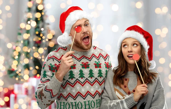 Paar mit Weihnachtsfeier-Requisiten in hässlichen Pullovern — Stockfoto