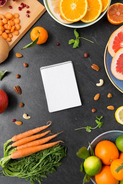 Close up of notebook, fruits and vegetables — Stock Photo, Image