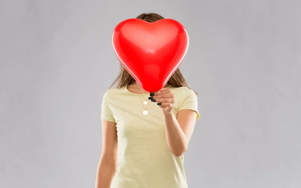 Kobieta zakrywająca twarz balonem w kształcie serca Obrazek Stockowy