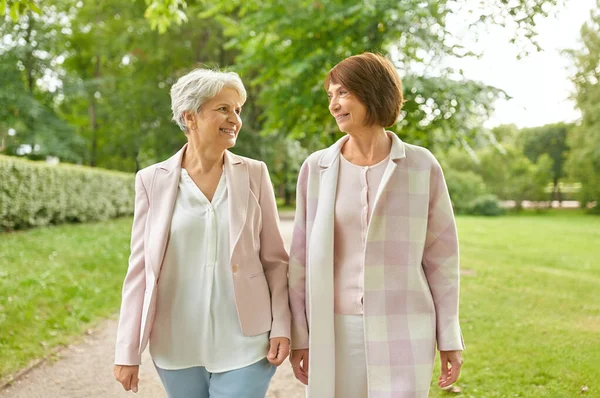 Seniora kvinnor eller vänner som går längs sommar parken — Stockfoto