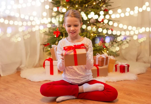 Leende flicka med julklapp hemma — Stockfoto