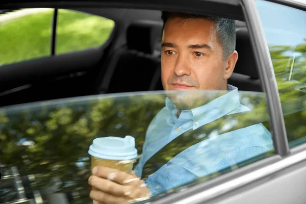 Homme buvant café à emporter sur le siège arrière de la voiture — Photo