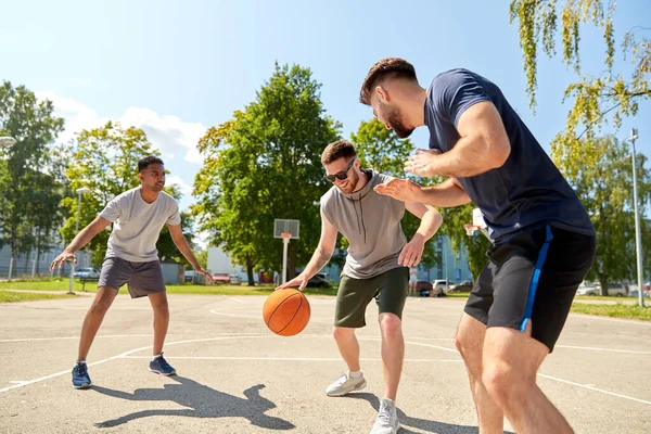 Skupina mužských přátel hrající pouliční basketbal — Stock fotografie