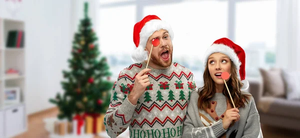 Para z christmas party rekwizyty w brzydkie swetry — Zdjęcie stockowe