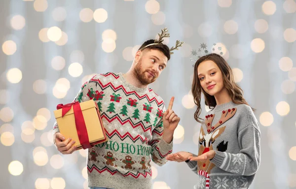 Felice coppia in brutti maglioni con regalo di Natale — Foto Stock