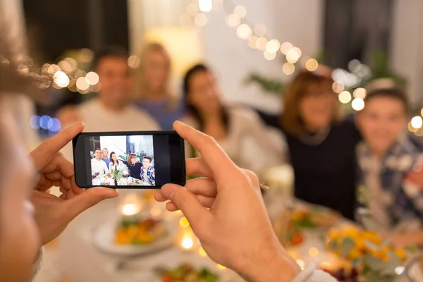 Man taking picture of family at dinner party — ストック写真