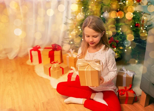 Menina sorridente com presente de Natal em casa — Fotografia de Stock