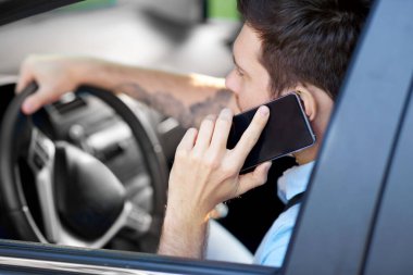 man driving car and calling on smartphone clipart