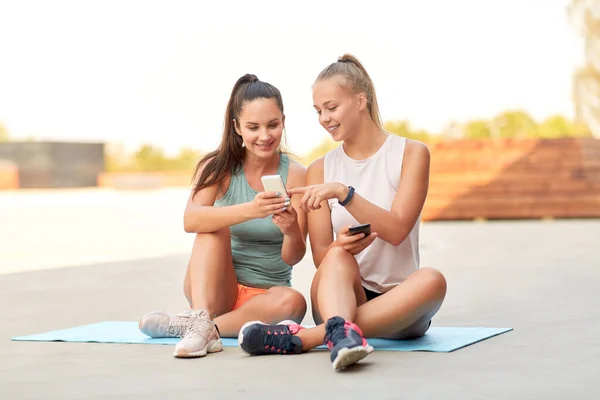 Sportliche Frauen oder Freunde mit Smartphone auf dem Dach — Stockfoto