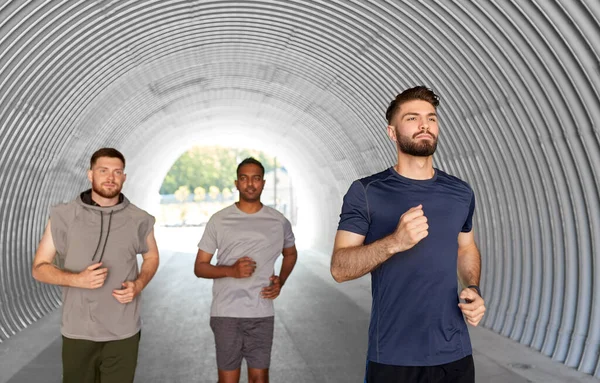Young men or male friends running outdoors — Stock Photo, Image