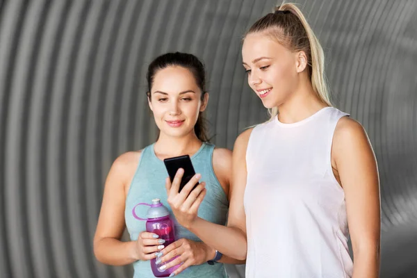 Vrouwen of vrouwelijke vrienden met smartphone en flacon — Stockfoto