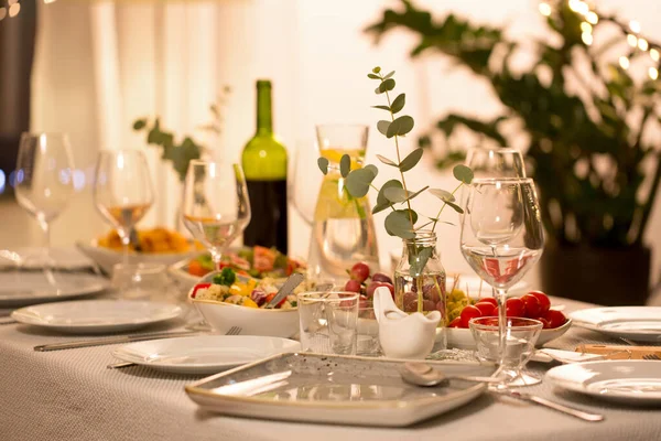 Tabaklar, şarap bardakları ve yiyeceklerle servis edilen masa. — Stok fotoğraf