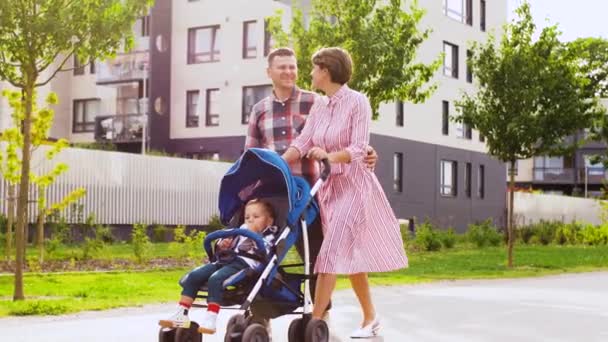Familia con bebé en cochecito caminando por la ciudad — Vídeos de Stock