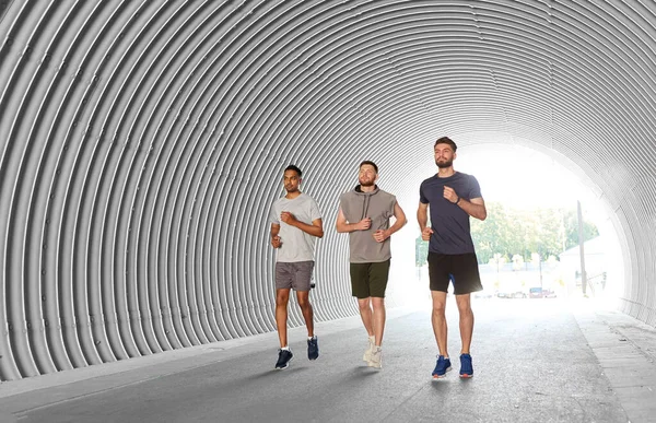 Young men or male friends running outdoors — Stock Photo, Image