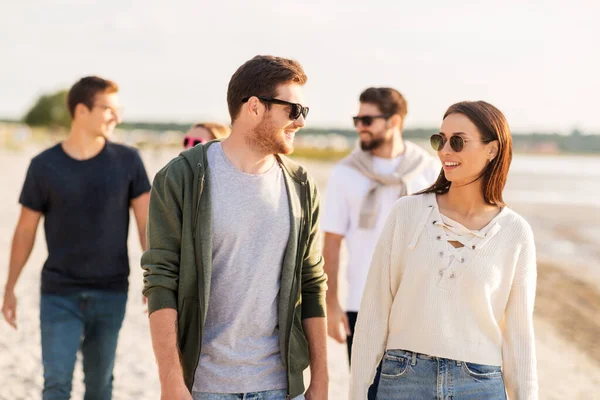 Amici felici passeggiando lungo la spiaggia estiva — Foto Stock