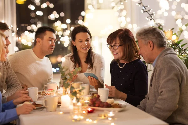 Happy family with smartphone at tea party at home — Stock Photo, Image