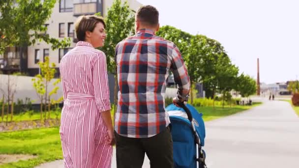 Famiglia con bimbo in passeggino passeggiando lungo la città — Video Stock