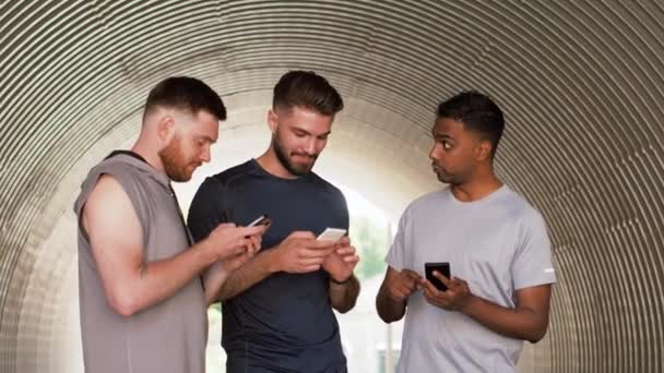 Homens ou amigos esportivos com smartphones ao ar livre — Vídeo de Stock