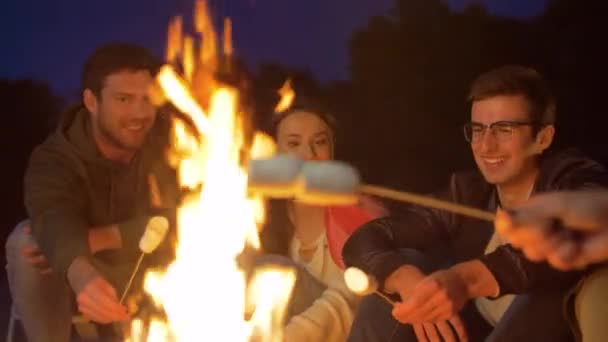 Freunde braten nachts Marshmallow am Lagerfeuer — Stockvideo