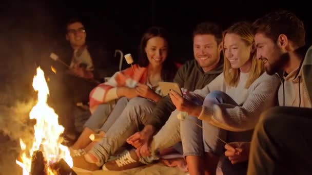 Amigos com marshmallow e smartphone em fogo — Vídeo de Stock