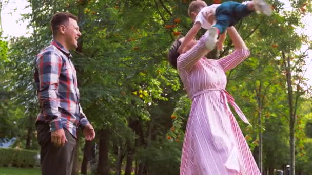 Lycklig familj spelar på sommarparken — Stockvideo