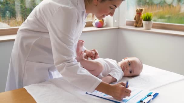 Médico pediatra feminino com bebê na clínica — Vídeo de Stock