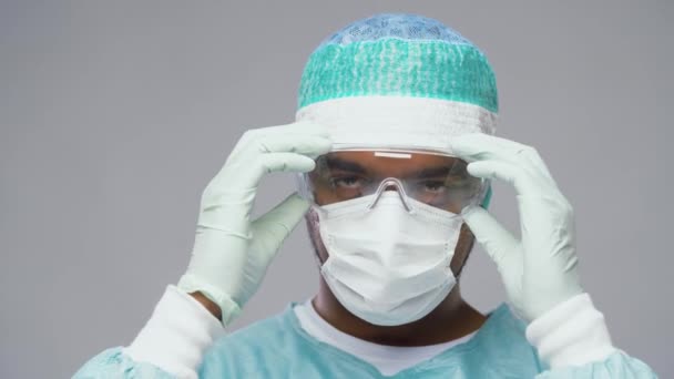 Tired surgeon taking facial mask and goggles off — Stock Video