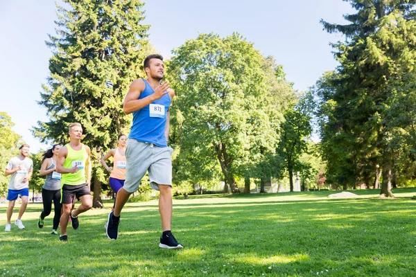 Felici giovani sportivi che corrono numeri di distintivo arguzia — Foto Stock