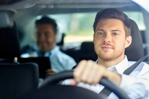 Male taxi driver driving car with passenger — Stock Photo, Image