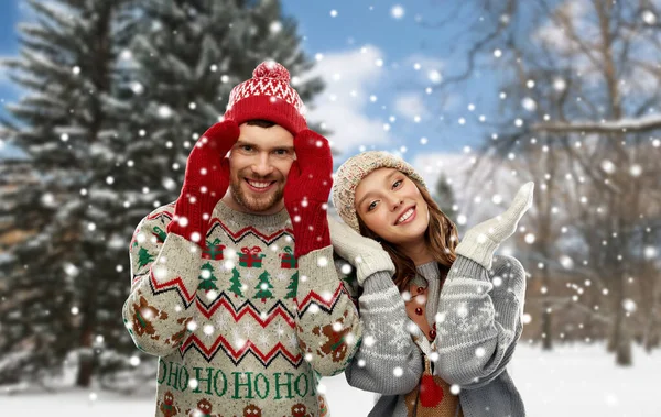 Happy couple in ugly christmas sweaters in winter — Stock Photo, Image