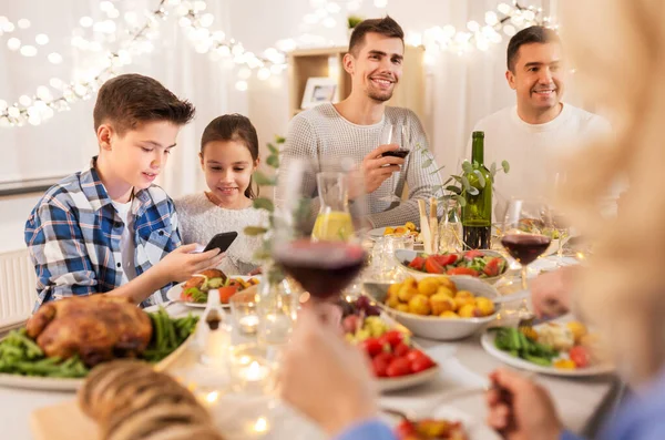 Barn med smartphone på familjemiddag fest — Stockfoto
