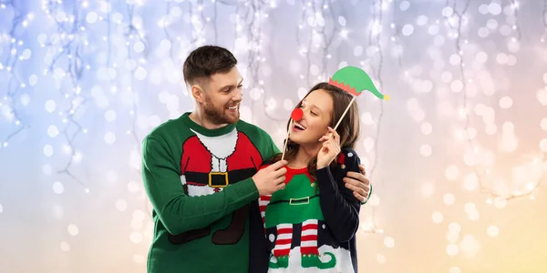 夫妇与圣诞派对道具穿着丑陋的毛衣 — 图库照片