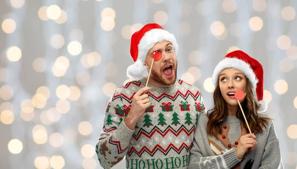 Couple with christmas party props in ugly sweaters — Stock Photo, Image