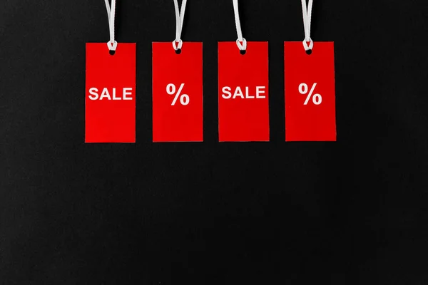 Red tags with discount signs on black background — Stock Photo, Image