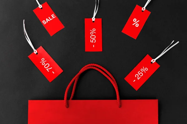 Червона сумка для покупок та теги зі знаками знижки — стокове фото