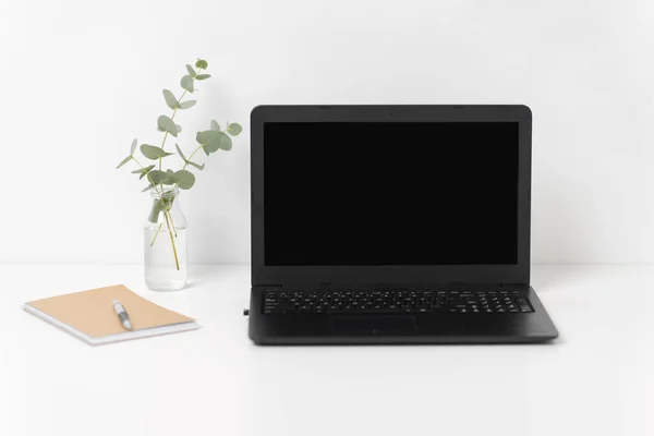 Ноутбук с черным экраном на белом столе офиса — стоковое фото