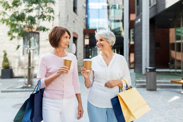 Senior vrouwen met boodschappentassen en koffie in de stad — Stockfoto