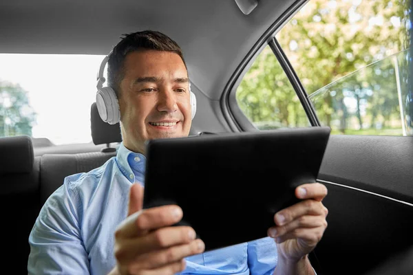 Passageiro com fones de ouvido usando tablet pc no carro — Fotografia de Stock