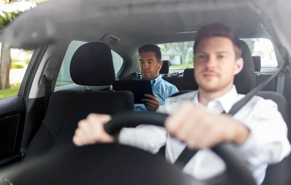 Homem com tablet pc e fones de ouvido equitação no carro — Fotografia de Stock