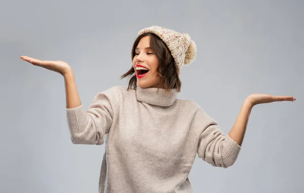 Jovem mulher no chapéu de inverno segurando algo — Fotografia de Stock