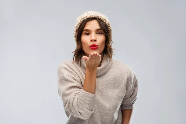 Mujer joven en punto sombrero de invierno enviando beso de aire Imagen de archivo