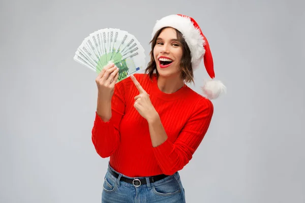 Mulher feliz em santa chapéu com dinheiro no Natal — Fotografia de Stock