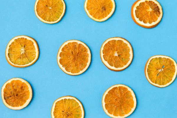 Gedroogde sinaasappelschijfjes op blauwe achtergrond — Stockfoto
