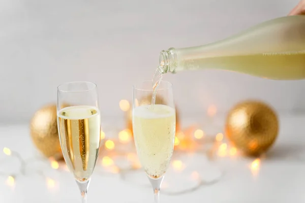 Šampaňské nalévání z láhve na vánoční skleničky — Stock fotografie