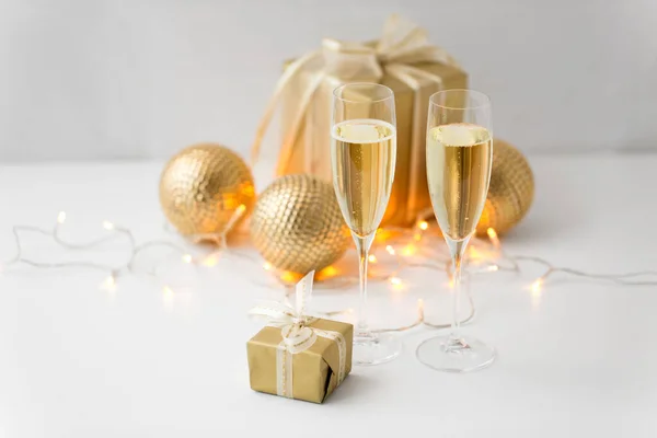 Gläser Champagner und Weihnachtsgeschenke — Stockfoto