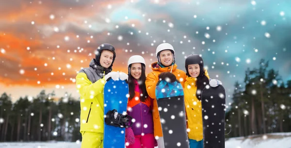 Amis heureux dans les casques avec snowboards en plein air — Photo