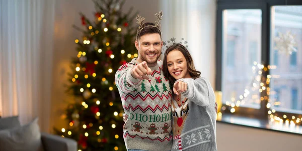 Happy couple at christmas ugly sweater party — Stock Photo, Image