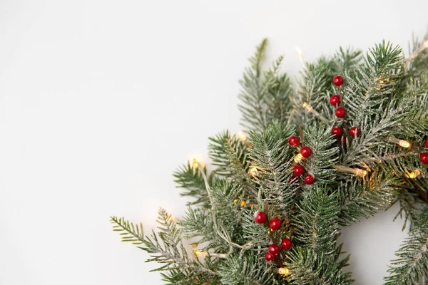 Vánoční jedle věnec s bobulemi a světly — Stock fotografie